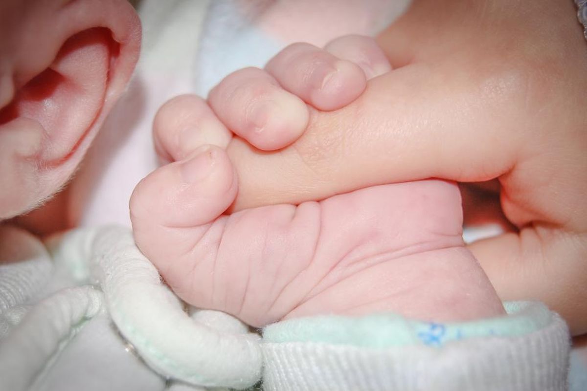 Jaundzimušā rociņa cieši satver pieaugušā pirkstu